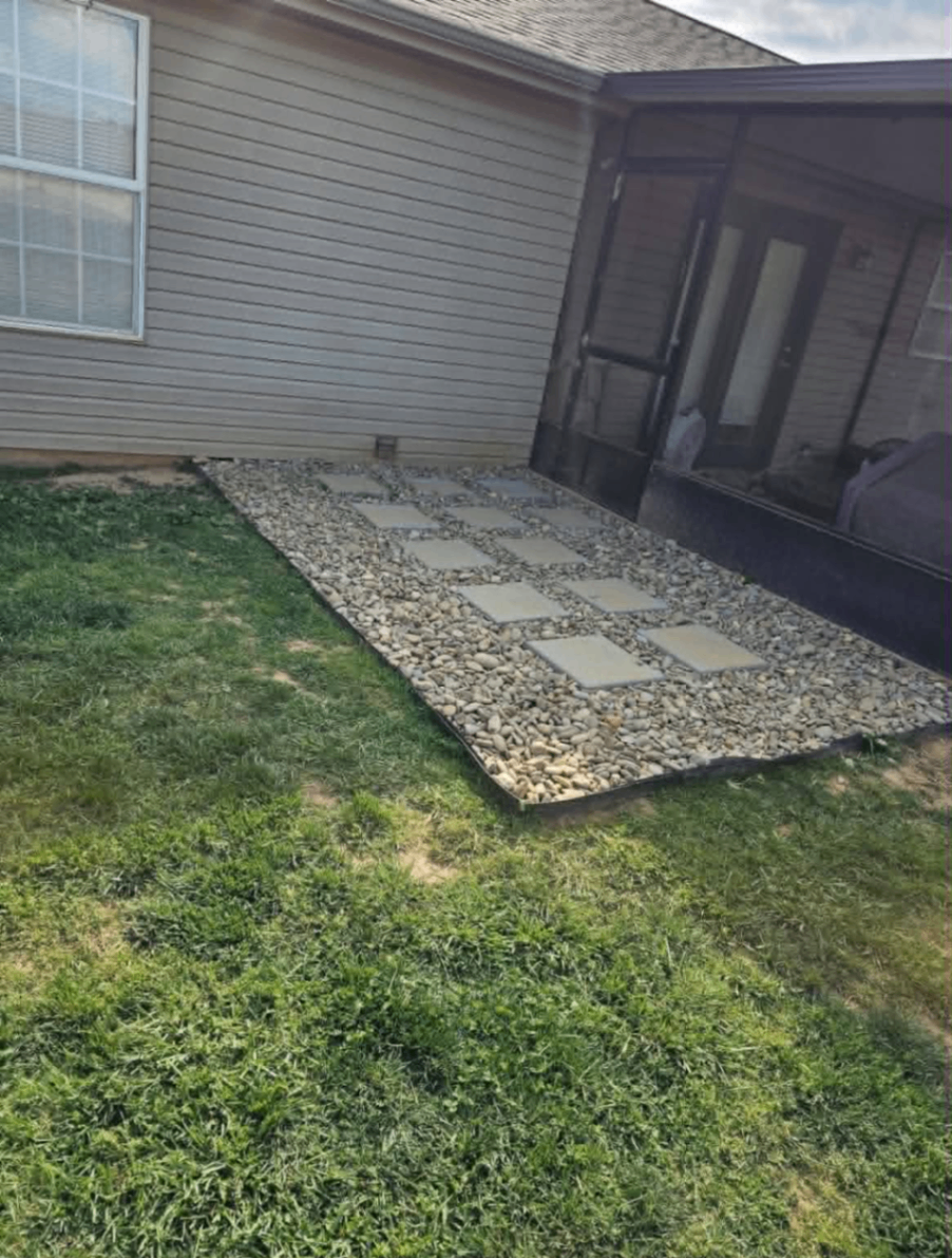 Wide view of a decorative stone path and porch edge landscaping