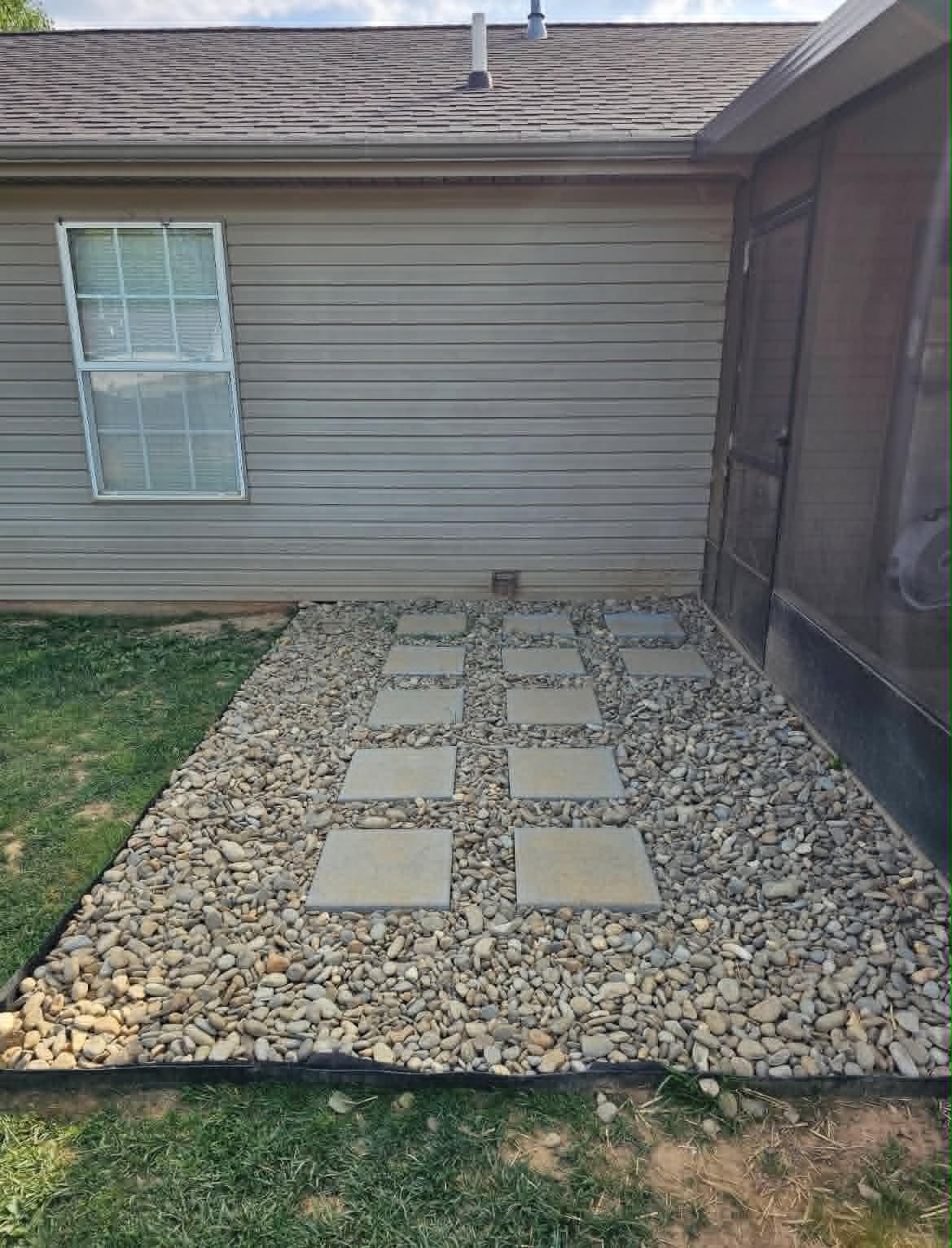 Decorative stone path with pavers beside a screened porch